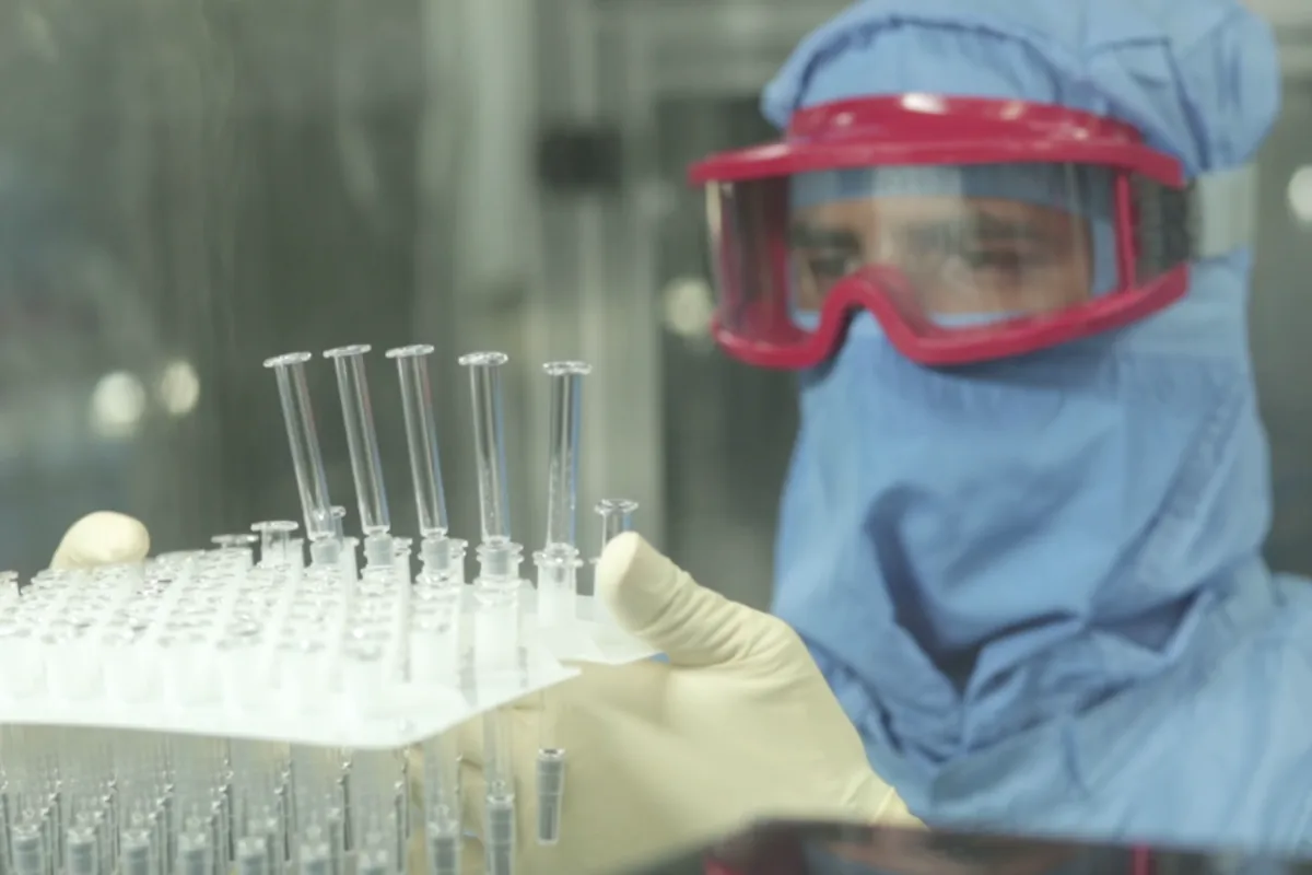 An operator inspecting a nest of prefilled syringes